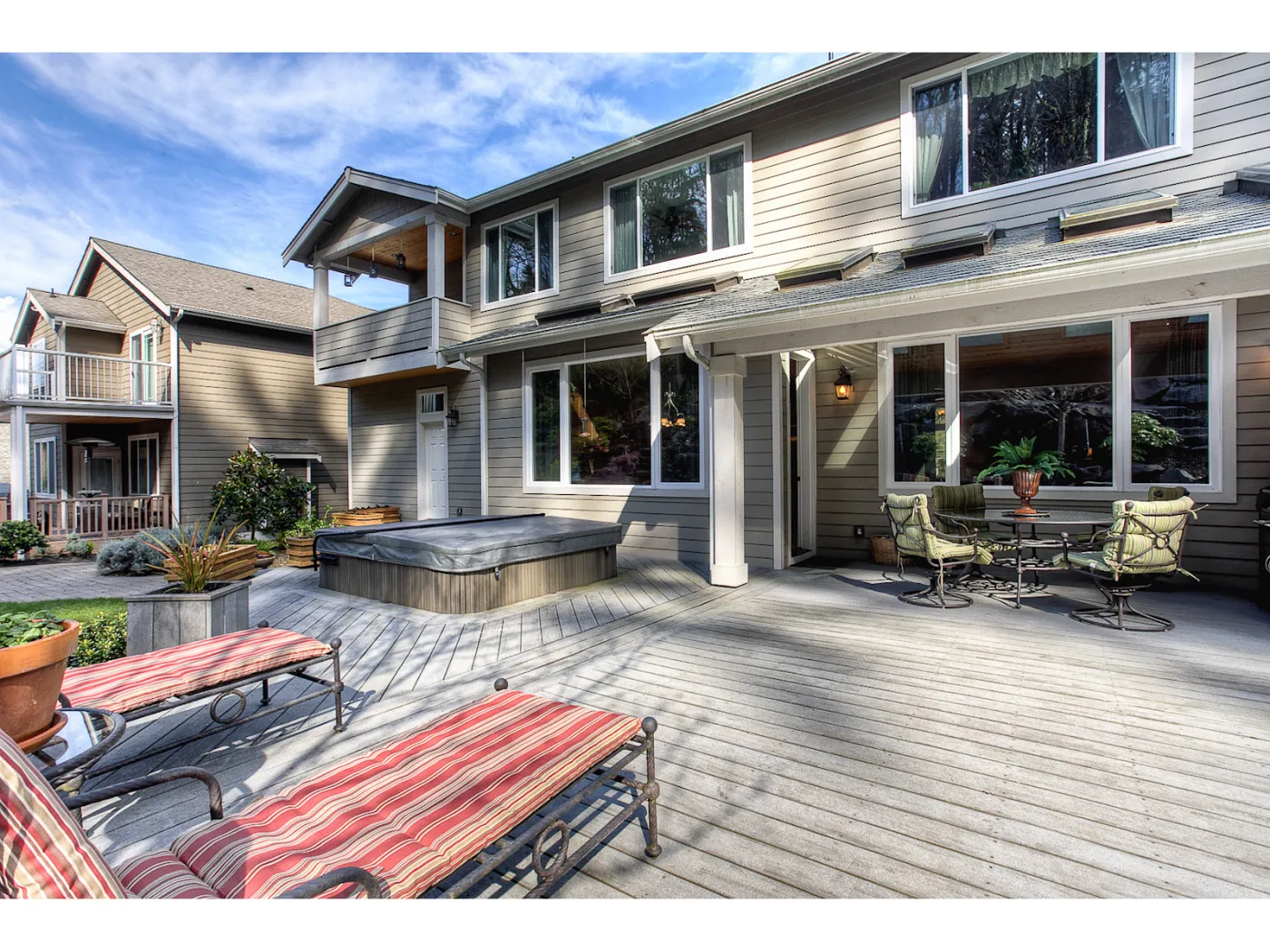 Kent home from the back: two storeys over a wide deck with a hot tub