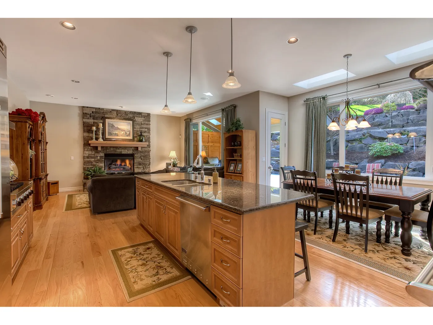 Seattle kitchen: long island with seating, maple cabinets, dining table beyond
